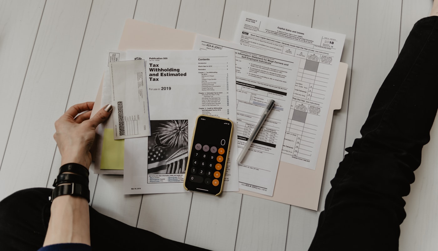 Calculator on a desk next to a coffee mug — tracking deductions